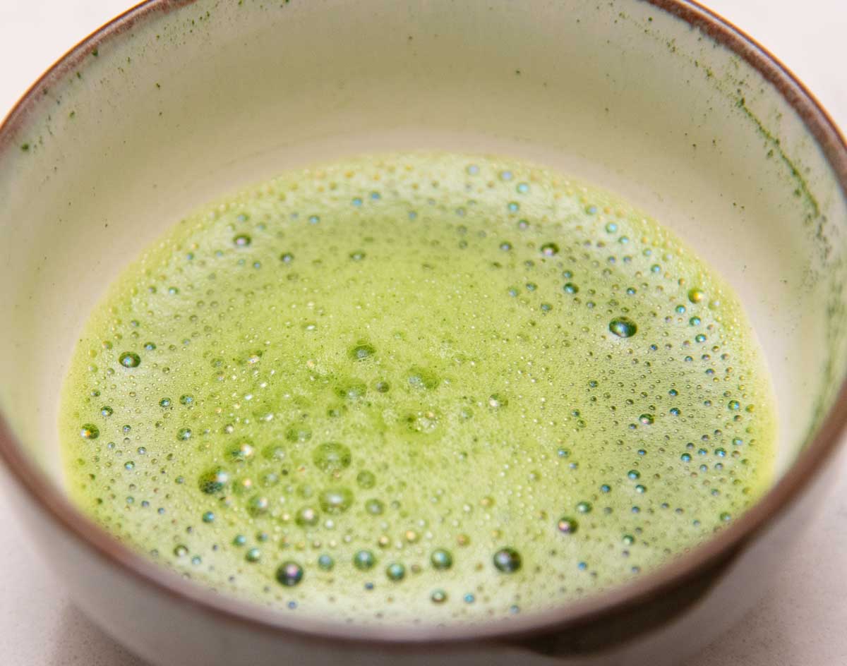whisked matcha in brown rimmed chawan